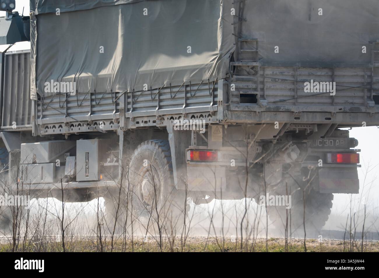 Primo piano di un UOMO dell'esercito britannico SV 4x4 verde scuro che si muove lungo una pista sterrata in campagna Foto Stock