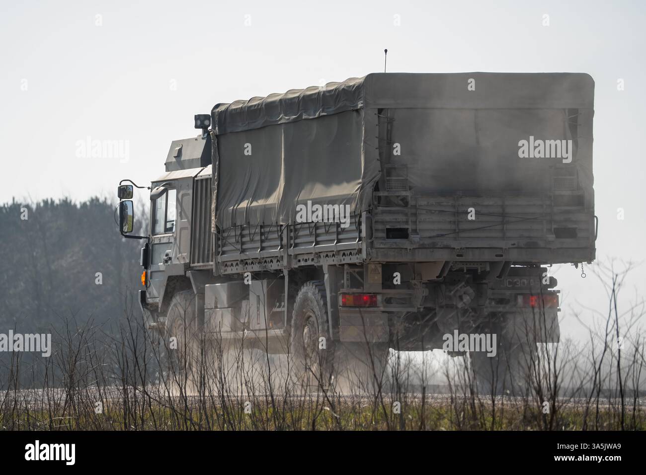 Primo piano di un UOMO dell'esercito britannico SV 4x4 verde scuro che si muove lungo una pista sterrata in campagna Foto Stock