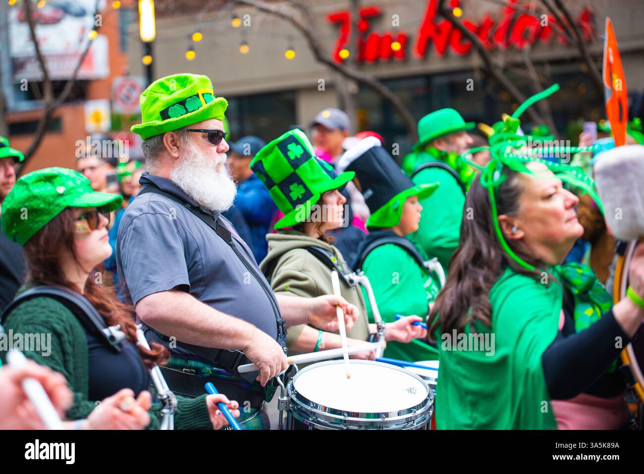 Montreal, Canada - 16 marzo 2025： persone che celebrano la sfilata di San Patrizio nel centro di Montreal Foto Stock