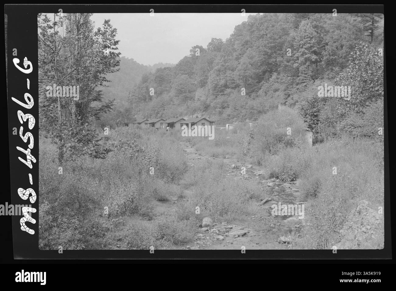 Vista di un ruscello dietro le case di Argyle, West Virginia, vicino alla miniera di Georges Creek nella contea di Logan. Questa immagine cattura il paesaggio di una comunità mineraria. Foto Stock