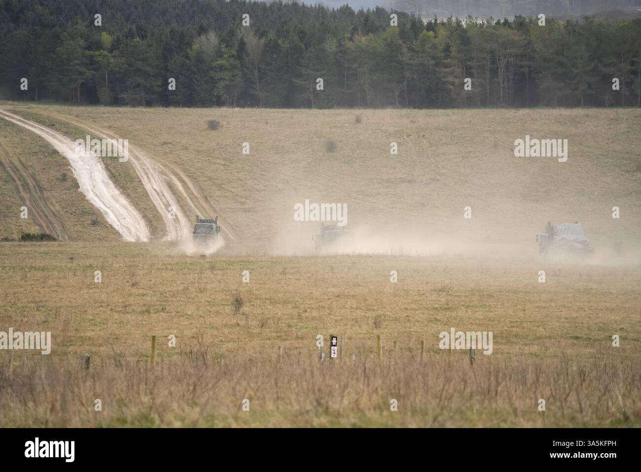 Convoglio dell'esercito britannico HX77 8x8 EPLS Heavy Utility Truck che trasporta rifornimenti in campagna, gettando polvere Foto Stock