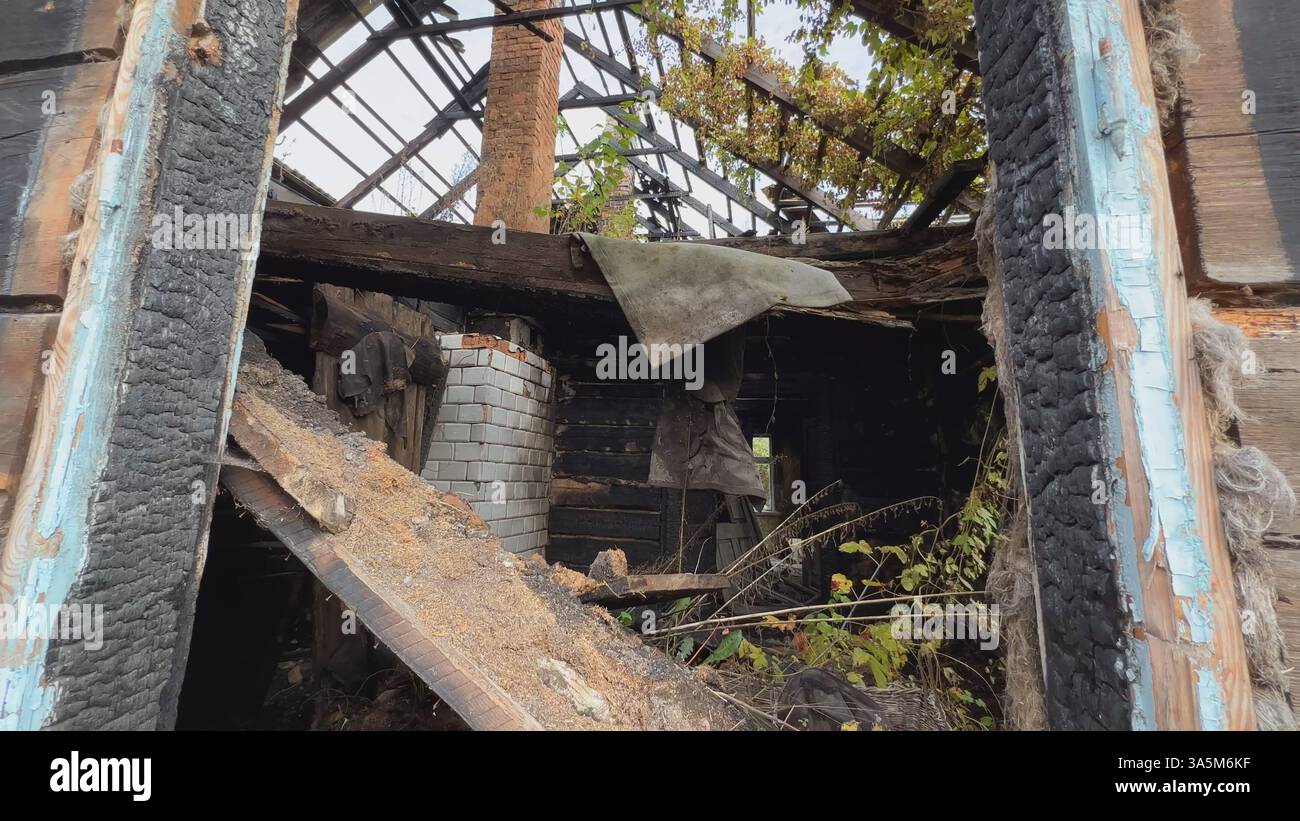 Resti di una casa di legno bruciata con camino in mattoni che rivelano un tragico incidente d'incendio Foto Stock