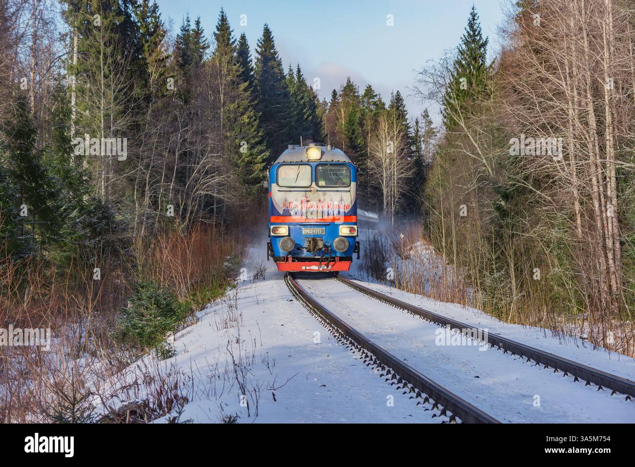 Sortavala, Russia - 15 febbraio 2025: Il treno di padre Frost si muove attraverso la foresta. Foto Stock