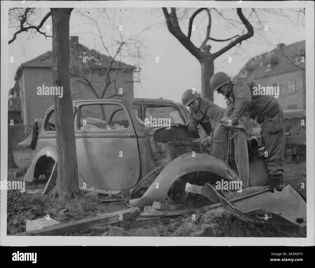 Il caporale Joseph F. Sousa e il caporale John L. Dudley salvano parti da un'auto civile tedesca distrutta durante la seconda guerra mondiale, contribuendo allo sforzo bellico. Foto Stock
