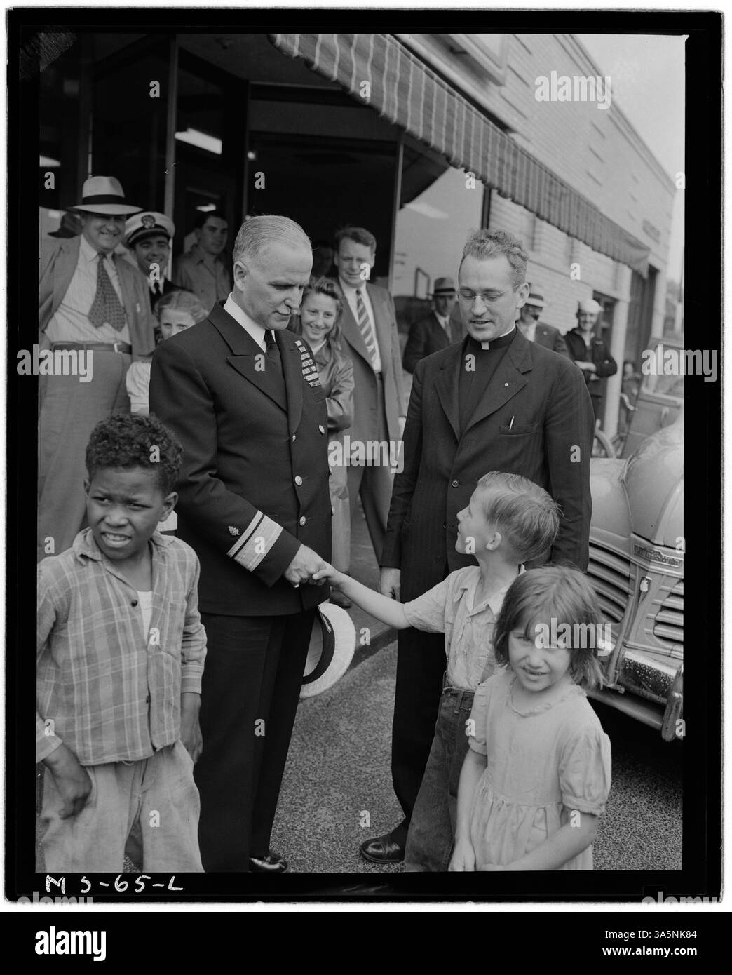 Questa fotografia del 1946 mostra il contrammiraglio Joel T. Boone che stringe la mano al figlio di un minatore alla miniera Westland Mine della Pittsburgh Coal Company a Westland, Contea di Washington, Pennsylvania. Padre J.H. McMahon di Pittsburgh guarda avanti. Foto Stock