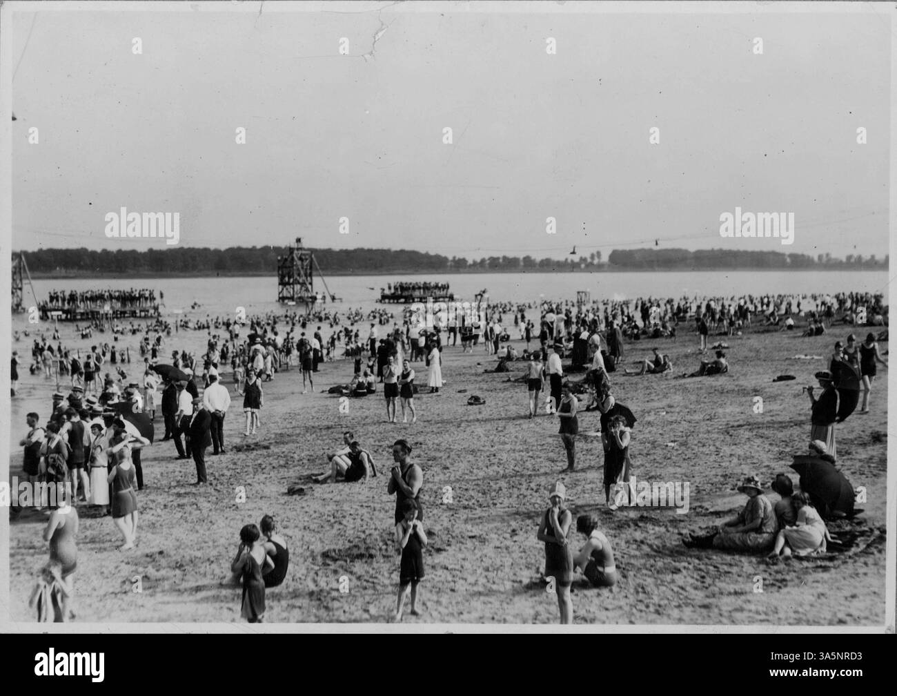 Popolare luogo di svago a Minneapolis, il lago Nokomis offre una spiaggia sabbiosa e un'area per nuotare. L'immagine mostra le persone che nuotano, si tuffano e prendono il sole in un'intensa giornata estiva. Foto Stock
