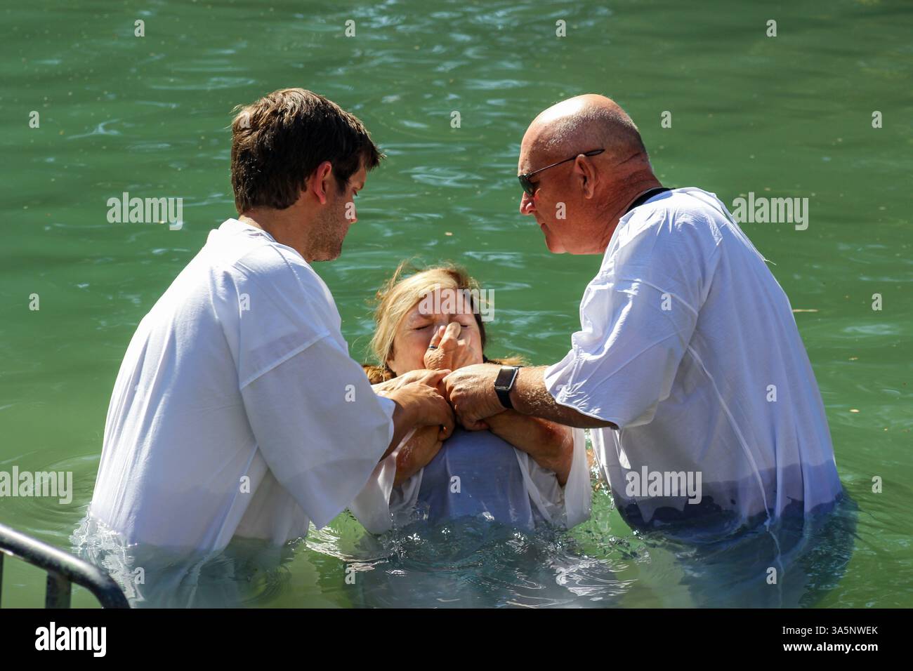 Una donna si chiude il naso mentre si prepara ad essere battezzata nel fiume Giordano presso il sito battisico Yardenit vicino a Kvutzat Kinneret, in Israele. Foto Stock