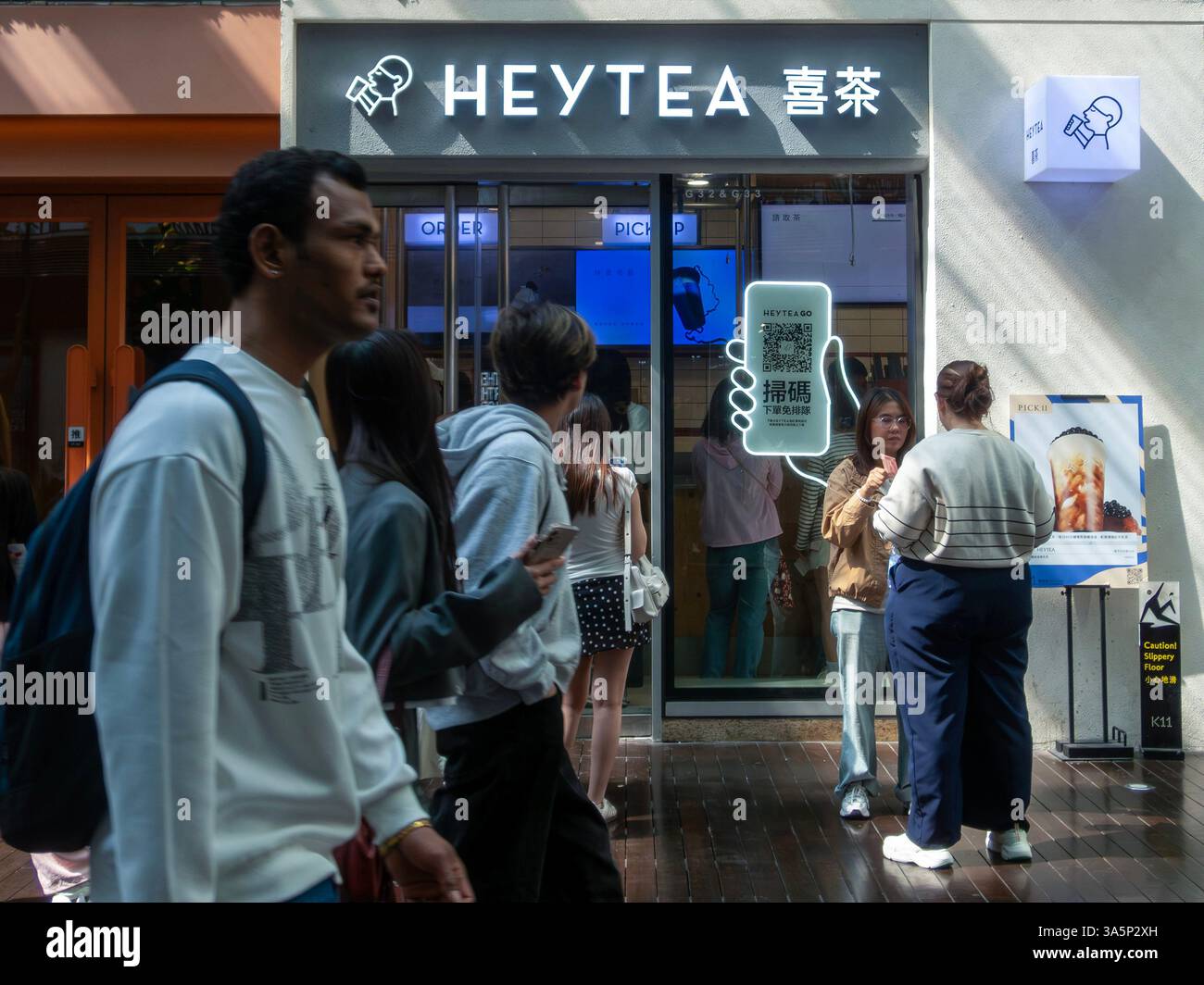Hong Kong, Cina. 23 marzo 2025. La gente si è vista passare davanti al negozio HEYTEA nel K11 Art Mall. HEYTEA, una famosa marca di tè cinese, ha aperto il suo primo negozio a Hong Kong nel 2018. Conosciuto per il suo caratteristico tè al formaggio, è diventato rapidamente una destinazione popolare per i turisti. (Foto di Pongmanat Tasiri/SOPA Images/Sipa USA) credito: SIPA USA/Alamy Live News Foto Stock