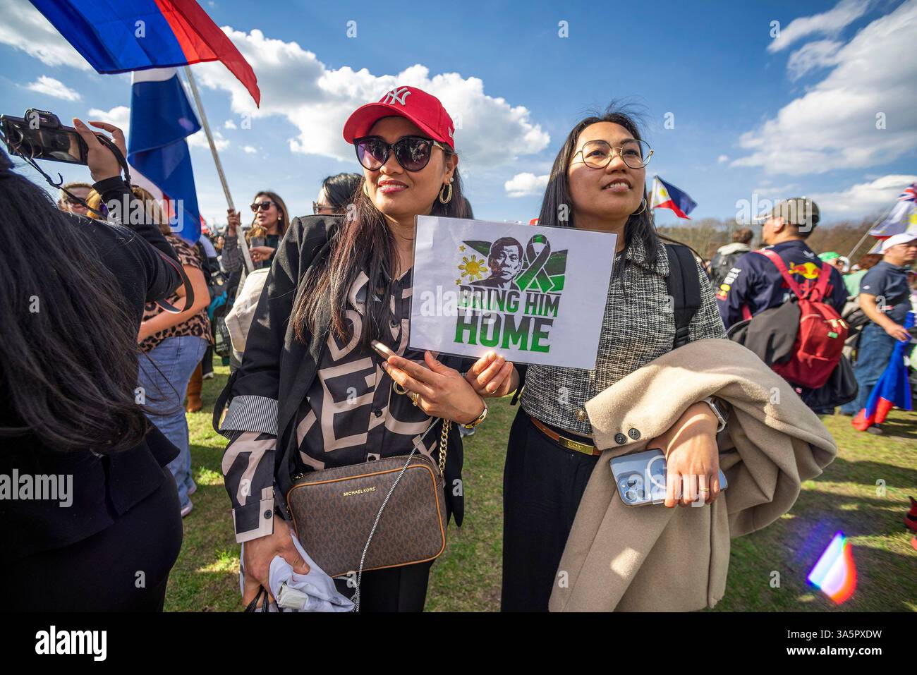 L'Aia, Paesi Bassi. 23 marzo 2025. Due tifosi femminili tengono un cartello che espone la loro opinione durante la manifestazione. I sostenitori dell'ex presidente Rodrigo Duterte delle Filippine, 79 anni, si sono riuniti a l'Aia nelle loro centinaia da tutta l'Unione europea e il Regno Unito per dimostrare sostegno al loro leader ora imprigionato. L'ex presidente attende un'audizione della Corte penale internazionale (ICC) martedì 23 settembre 2025. Questo determinerà se portare il caso contro di lui al processo. Se giudicato colpevole, Duterte potrebbe passare il resto della sua vita in prigione. Credito: SOPA i Foto Stock
