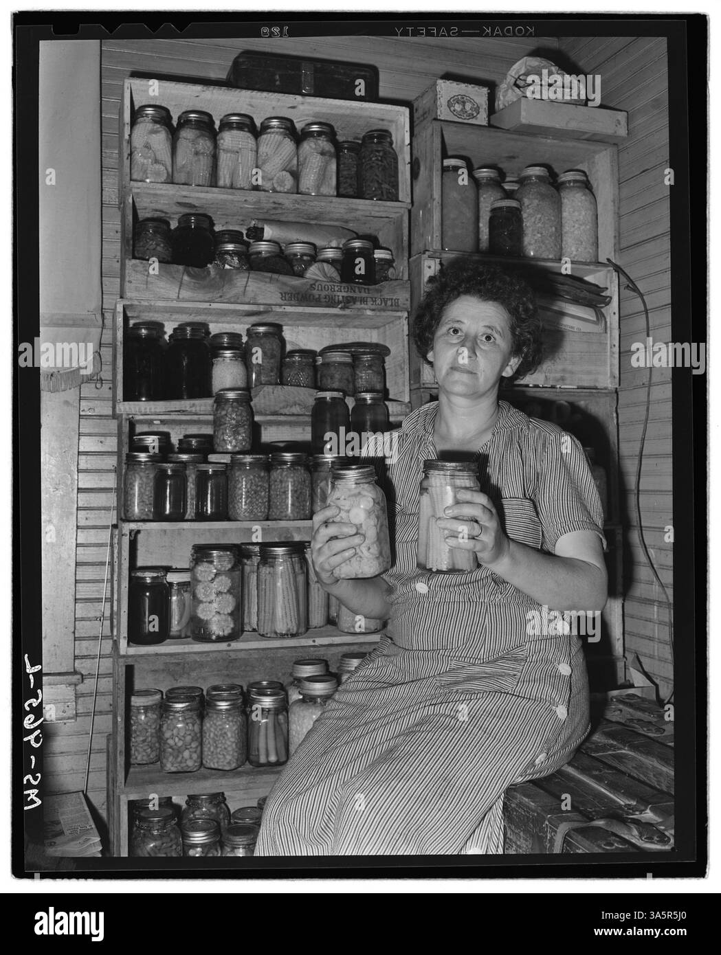 La signora Mack Brasseak, moglie di un minatore alla miniera di Bankhead nella contea di Walker, Alabama, regge verdure in scatola. Questa immagine, tratta dagli Archivi nazionali, mette in evidenza il ruolo domestico delle mogli dei minatori nella comunità. Foto Stock