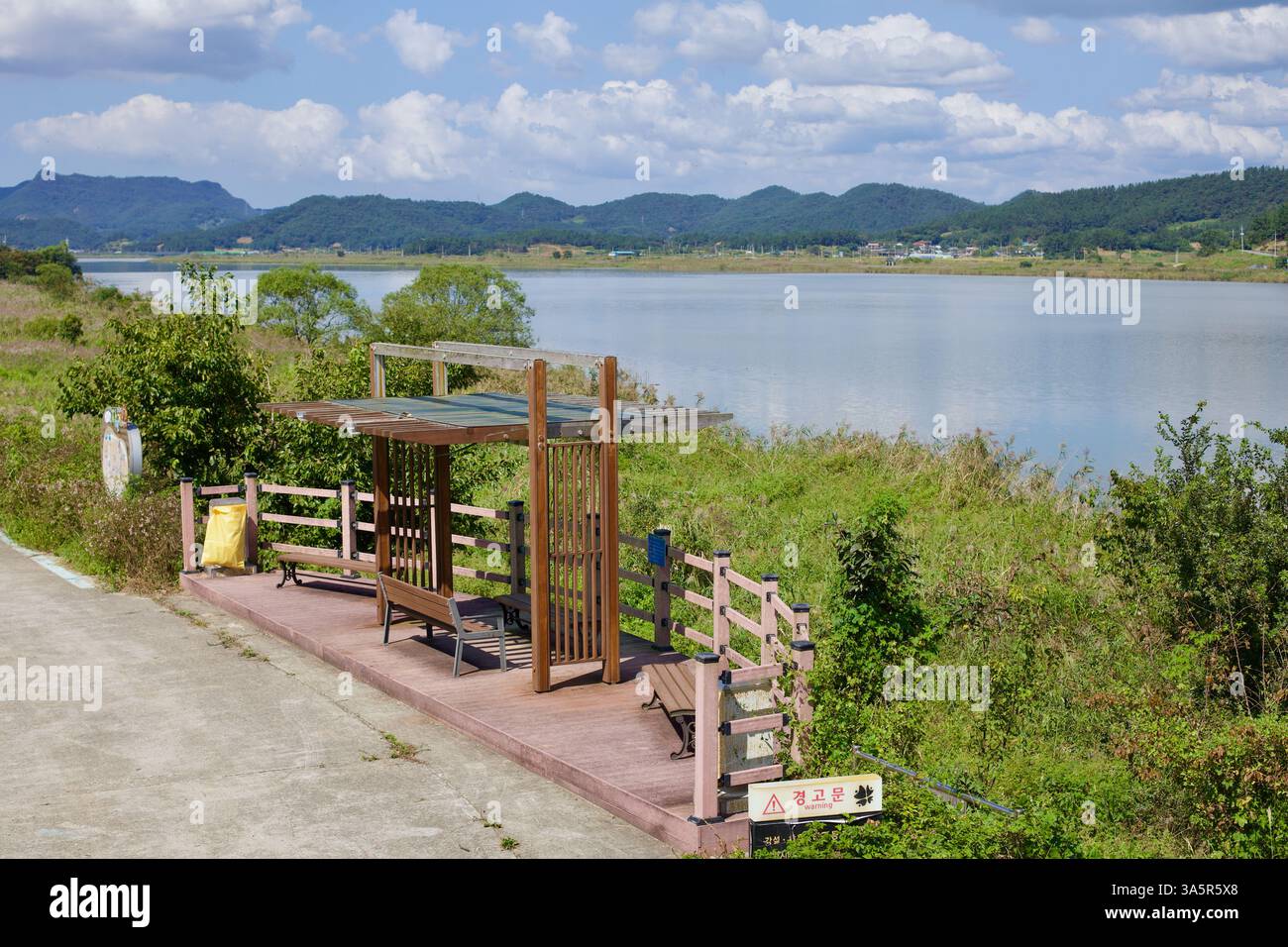 Contea di Muan, Corea del Sud - 25 settembre 2020: Una sosta di riposo in legno con panchine e ombra parziale si affaccia sul fiume Yeongsan lungo il Yeongsangang B. Foto Stock