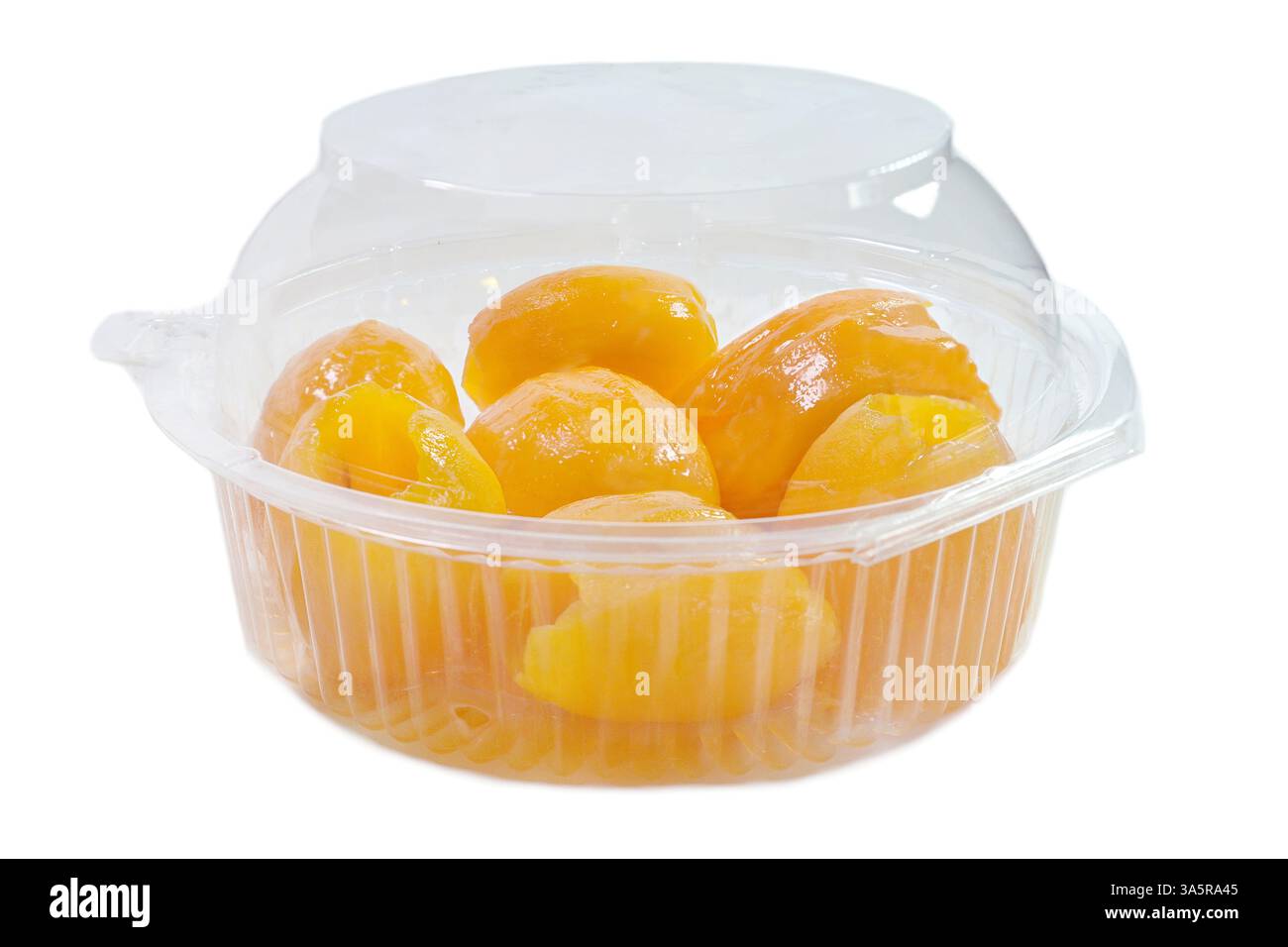 Vista laterale di un punzone in plastica trasparente di medie dimensioni contenente prugne mariane gialle mature scuoiate e senza semi o frutta maionese confezionata in vendita Foto Stock