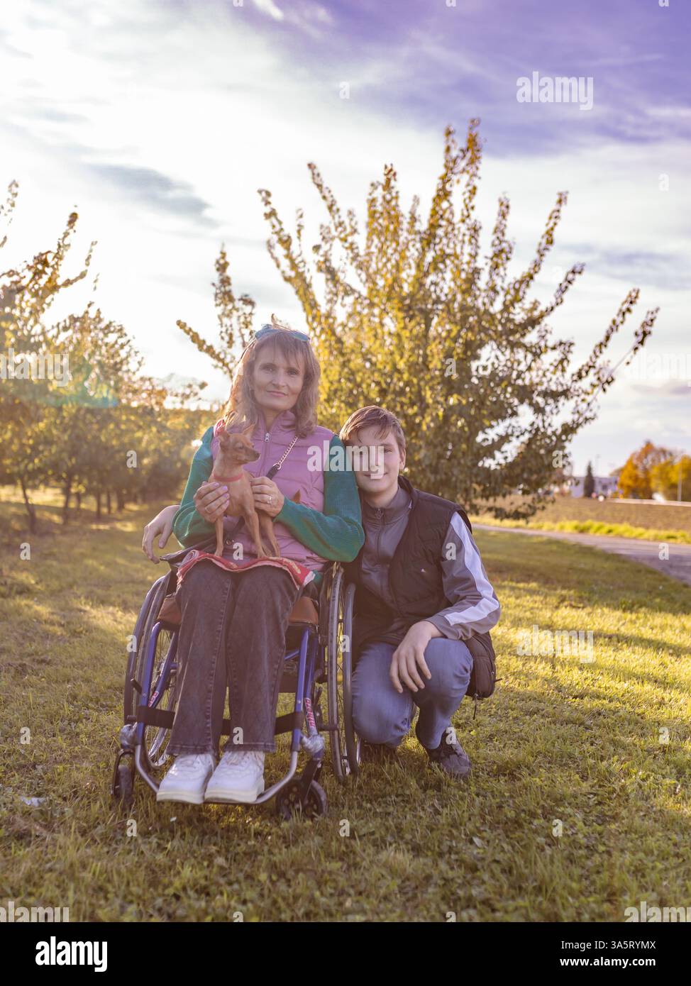 La famiglia con un figlio adolescente cammina nel frutteto Foto Stock
