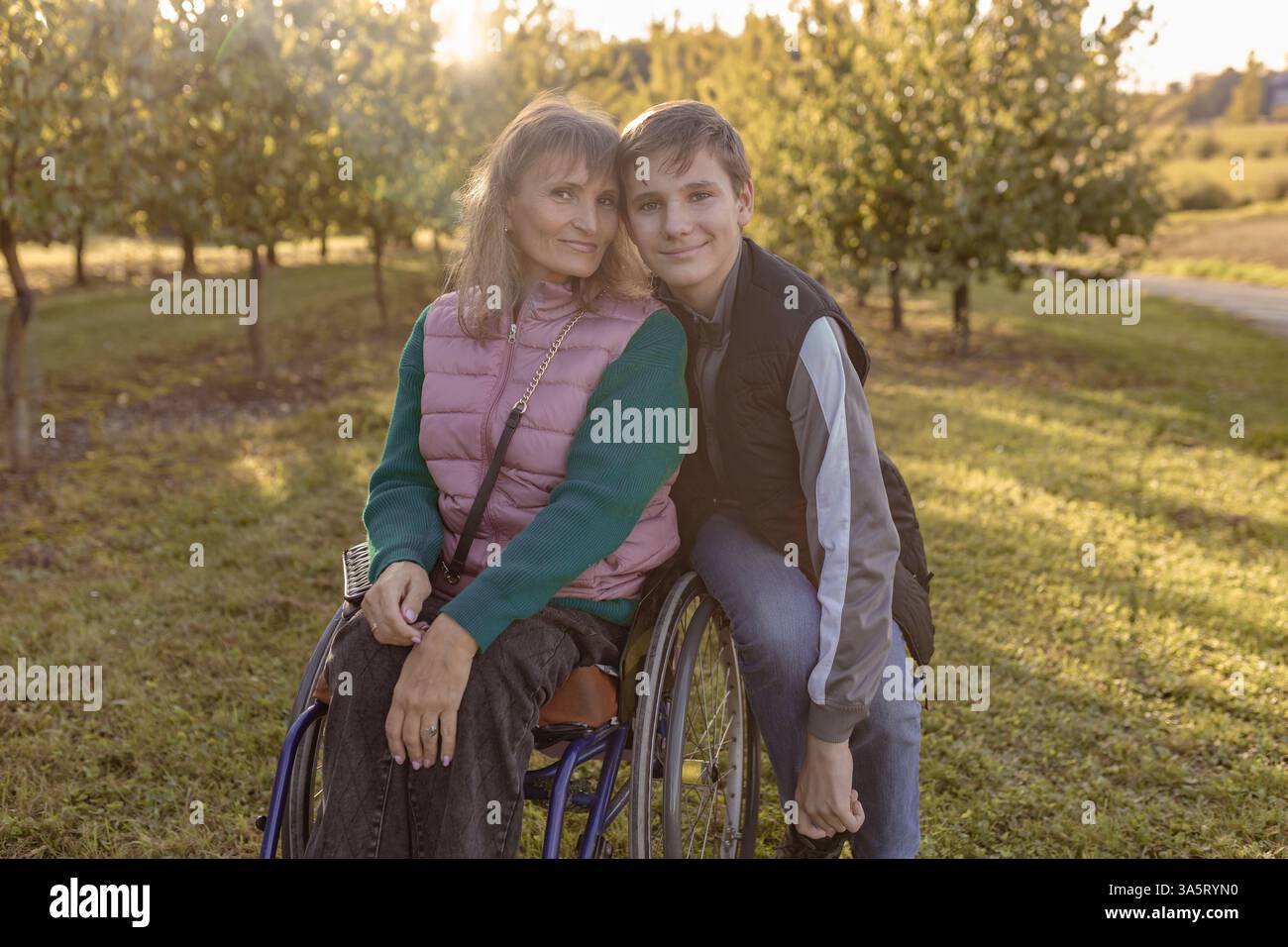 La famiglia con un figlio adolescente cammina nel frutteto Foto Stock