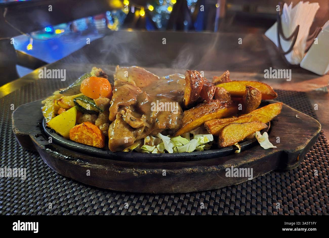 Un piatto di pollo con patate e verdure frizzanti. Foto Stock