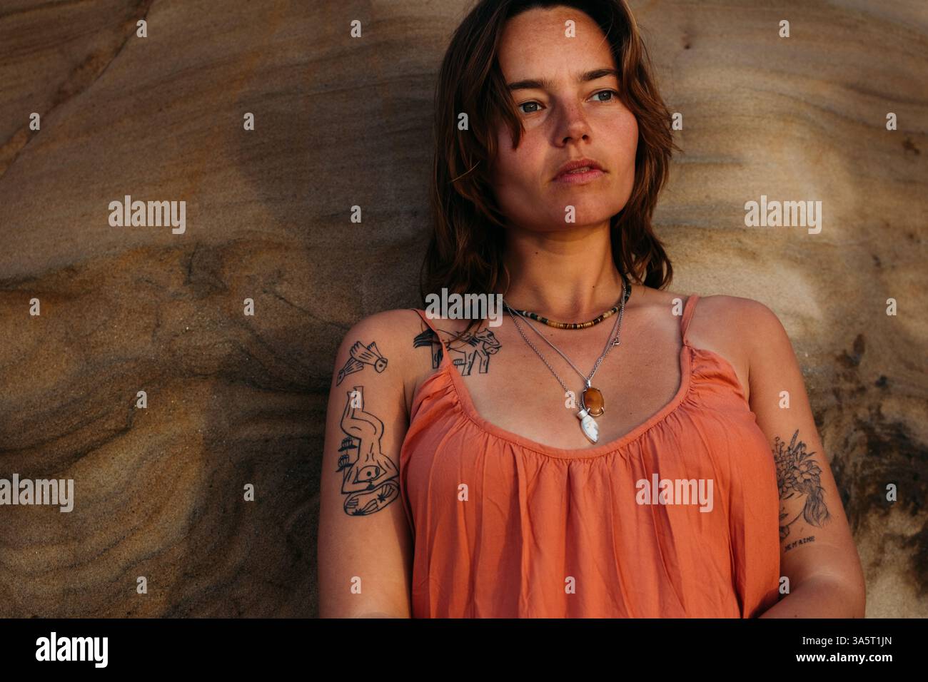 Donna forte che guarda in lontananza contro la roccia di arenaria Foto Stock