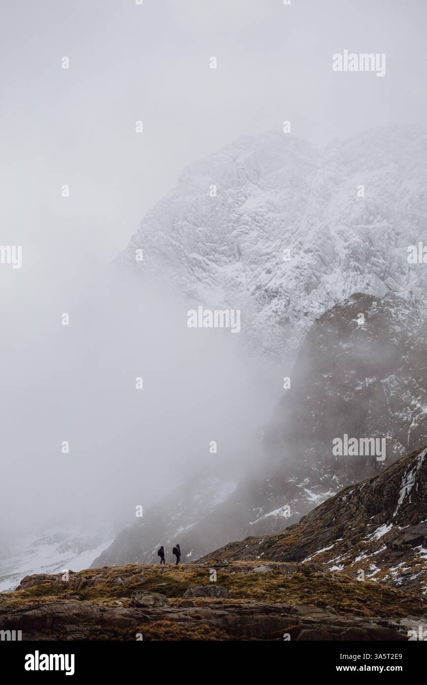 Due alpinisti invernali che guardano le Snowy Scottish Peaks Foto Stock