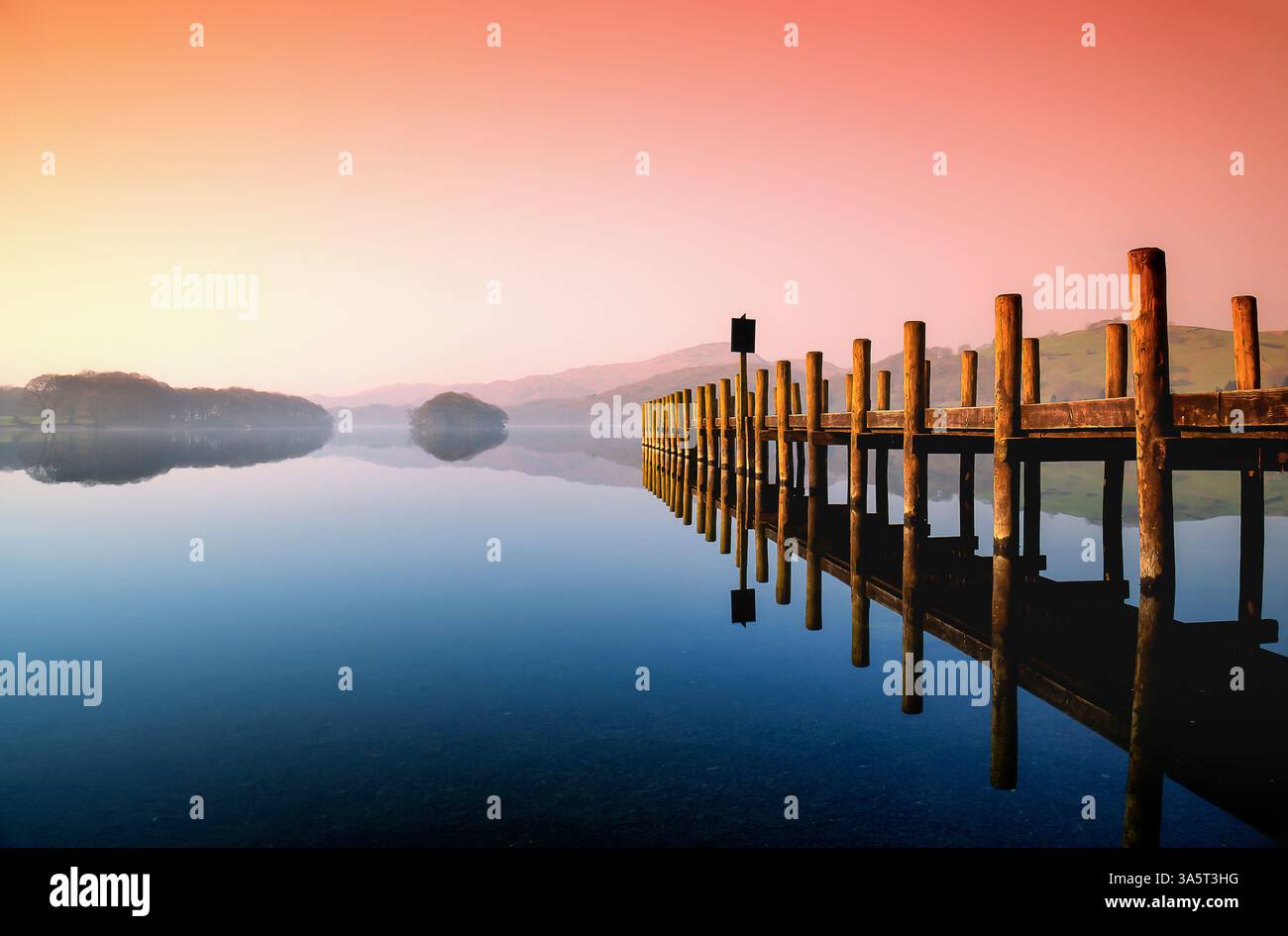 Coniston Sunrise e il molo nel distretto lacustre della Cumbria Foto Stock