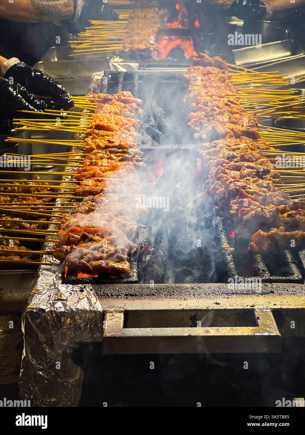 Satay grigliato sul fuoco aperto, carbone di legna nella via satay di Singapore, Asia Foto Stock