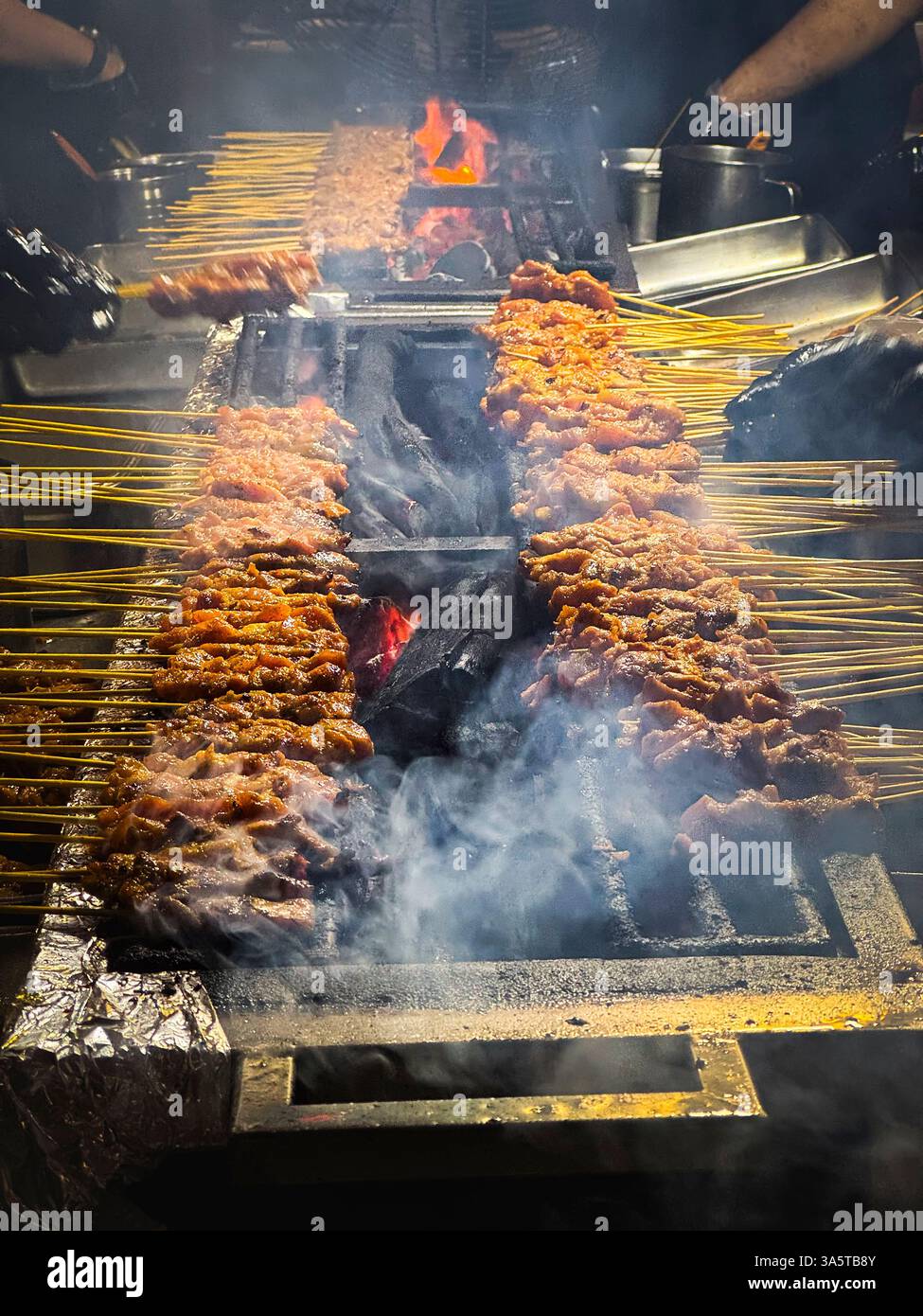 Satay grigliato sul fuoco aperto, carbone di legna nella via satay di Singapore, Asia Foto Stock