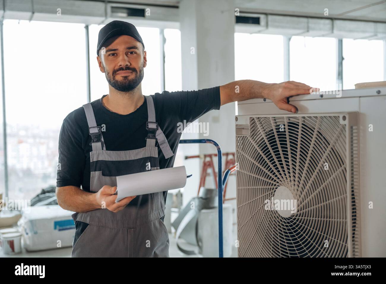 Grande condizionatore d'aria. Un uomo sta ristrutturando una stanza incompiuta. Foto Stock