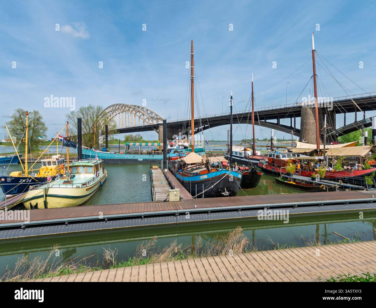 Barche nel porto di Lindenbergaven sul fiume Waal accanto al ponte Waal nella città Duch di Nijmegen, Gelderland, Paesi Bassi. Foto Stock