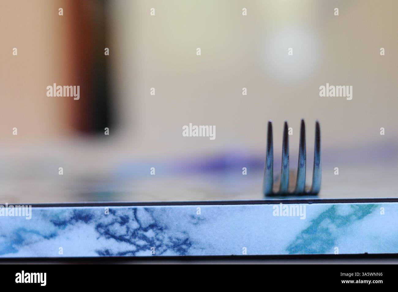 Forchetta verticale su superficie in marmo, evidenzia la semplicità e il minimalismo nel design Foto Stock