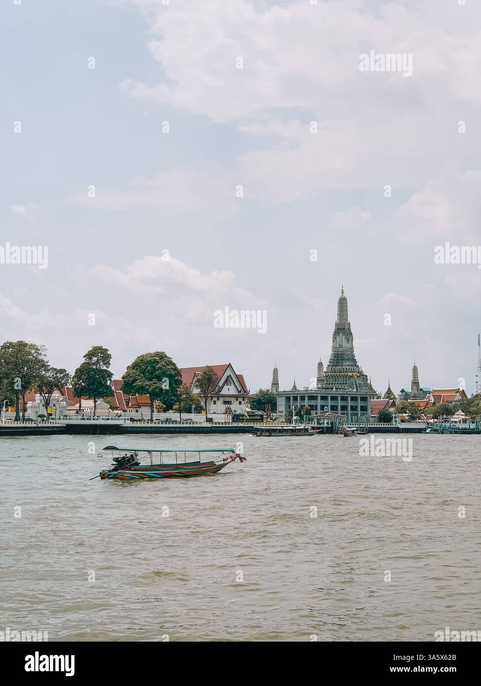 Barca tradizionale sull'acqua a Bangkok con il Tempio Wat Arun sullo sfondo Foto Stock