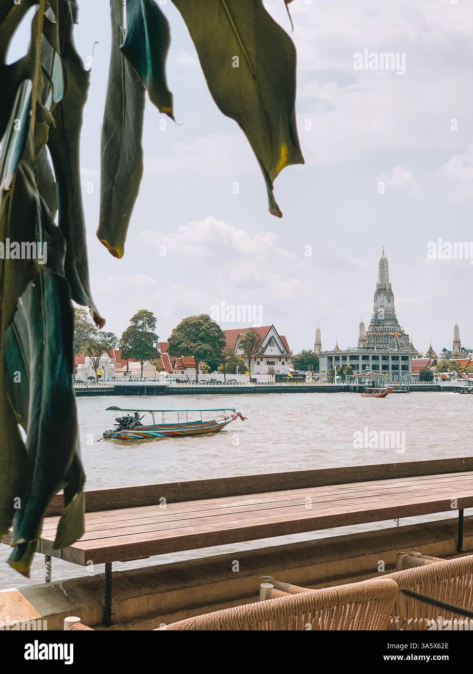 Barca tradizionale sull'acqua a Bangkok con il Tempio Wat Arun sullo sfondo Foto Stock