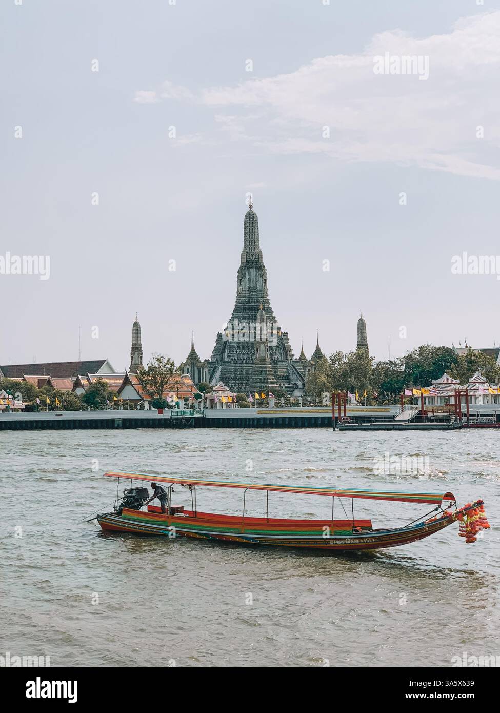 Barca tradizionale sull'acqua a Bangkok con il Tempio Wat Arun sullo sfondo Foto Stock