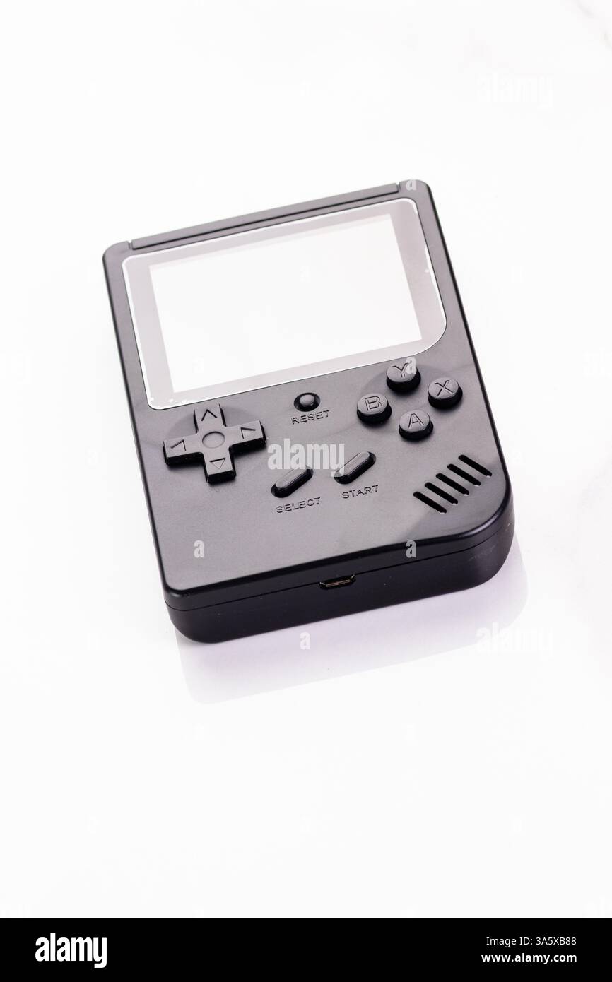 Una console portatile nera stilizzata con pulsanti classici, isolata contro il bianco. Questo dispositivo compatto evoca nostalgici ricordi di gioco e. Foto Stock