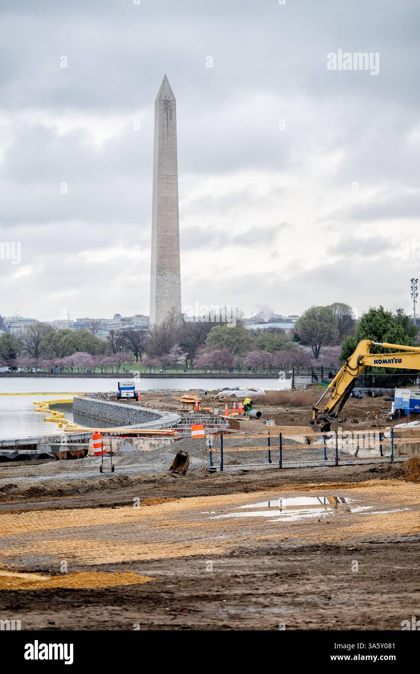 WASHINGTON DC - il Tidal Basin Seawall Reconstruction Project mostra lavori in corso nell'angolo meridionale del bacino Tidal il 24 marzo 2025. L'iniziativa del National Park Service affronta il deterioramento significativo e le frequenti inondazioni della storica diga, originariamente costruita all'inizio del XX secolo. Questo progetto di riabilitazione delle infrastrutture ha lo scopo di preservare l'accesso ai famosi passaggi pedonali che circondano il bacino delle Tidal, proteggendo al contempo i preziosi ciliegi e monumenti della zona dalle intrusioni d'acqua. Foto Stock