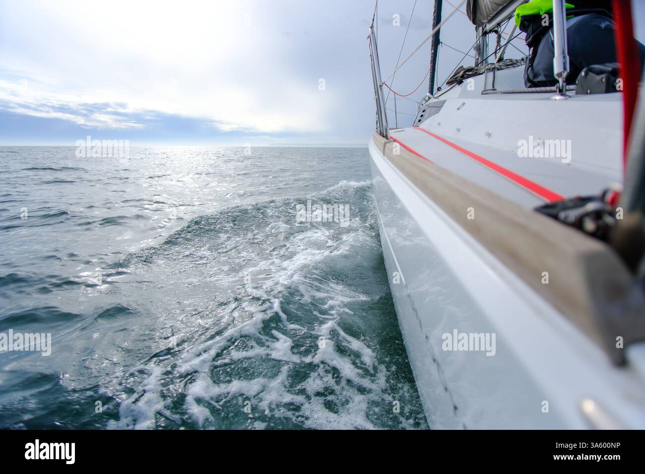 23 marzo 2025 - Una barca a vela che regala e si muove rapidamente attraverso l'acqua, navigando nelle condizioni atmosferiche del Canale della Manica. Foto Stock