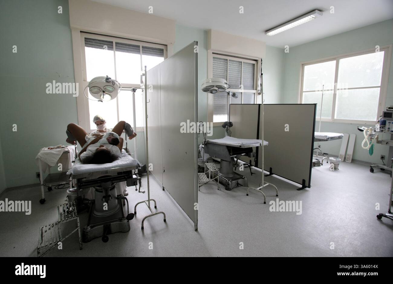 4 luglio 2008 - Rejane Caeira, 18 anni, riceve cure mediche mentre tiene il suo bambino appena nato all'ospedale di maternità Pro Matre di Rio de Janeiro, Brasile. Il Brasile ha un tasso straordinariamente alto di nascite cesaree al 44%, secondo un recente studio del Ministero della salute. Gli esperti affermano che il tasso è dovuto a fattori ''culturali'', nonché a pressioni da parte di ospedali privati, che devono giustificare gli investimenti in tecnologia. In un recente studio pubblicato nel numero di giugno 2008 di Ostetricia e Ginecologia, il parto cesareo è stato associato ad un aumentato rischio di complicazioni in una gravidanza successiva. (Dougla Foto Stock