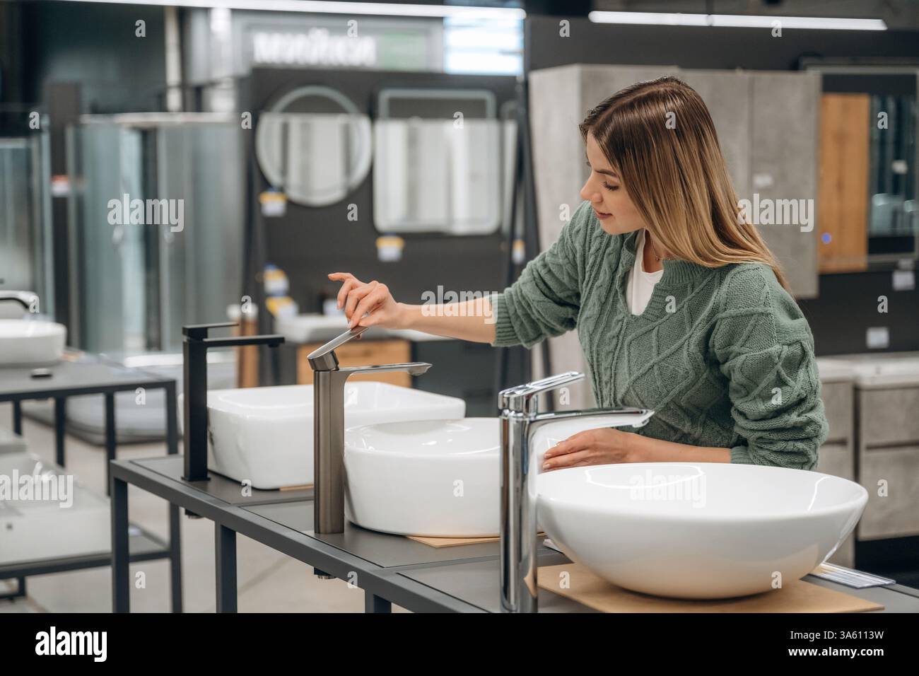 Test del lavandino. La donna è nel negozio di ferramenta, ideazione per lo shopping. Foto Stock