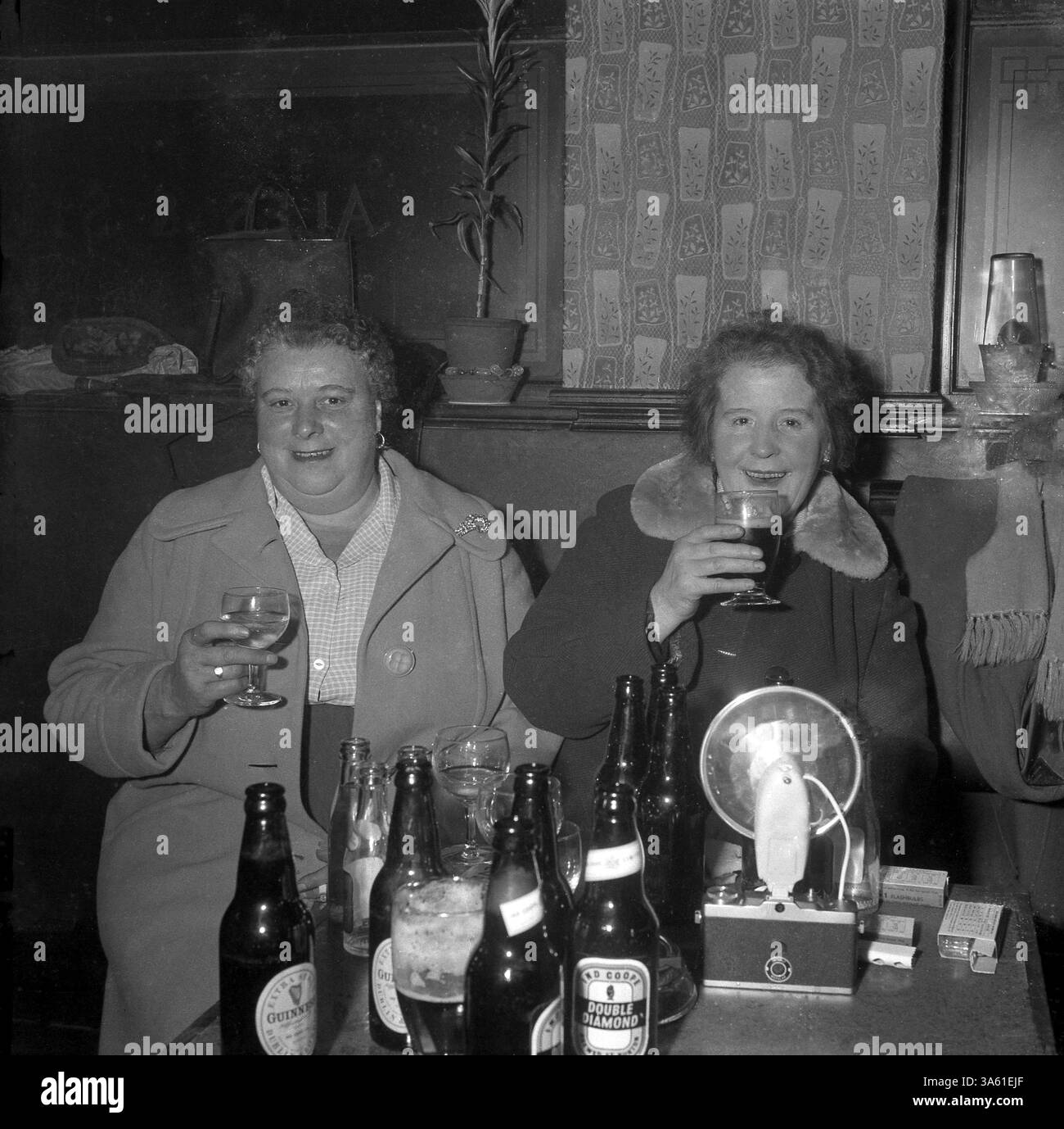Anni '1950, storico, all'interno di un pub dell'East End, due signore mature sedute insieme a bere un drink, Londra, Inghilterra, Regno Unito. Foto Stock