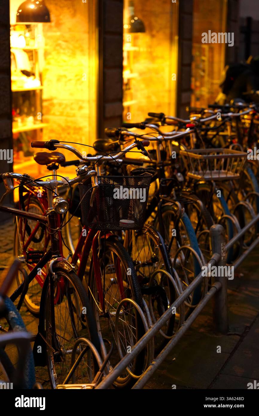 La cultura della bicicletta della Danimarca riassume in questa immagine. Mostra le biciclette parcheggiate in fila nella città vecchia di Copenaghen durante una fredda serata invernale Foto Stock