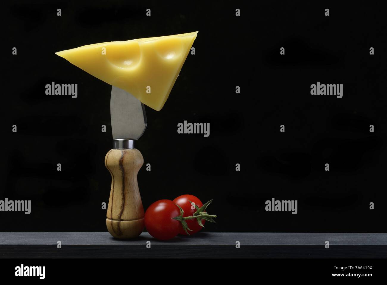 Un pezzo di formaggio svizzero Emmental su un coltello da formaggio Foto Stock