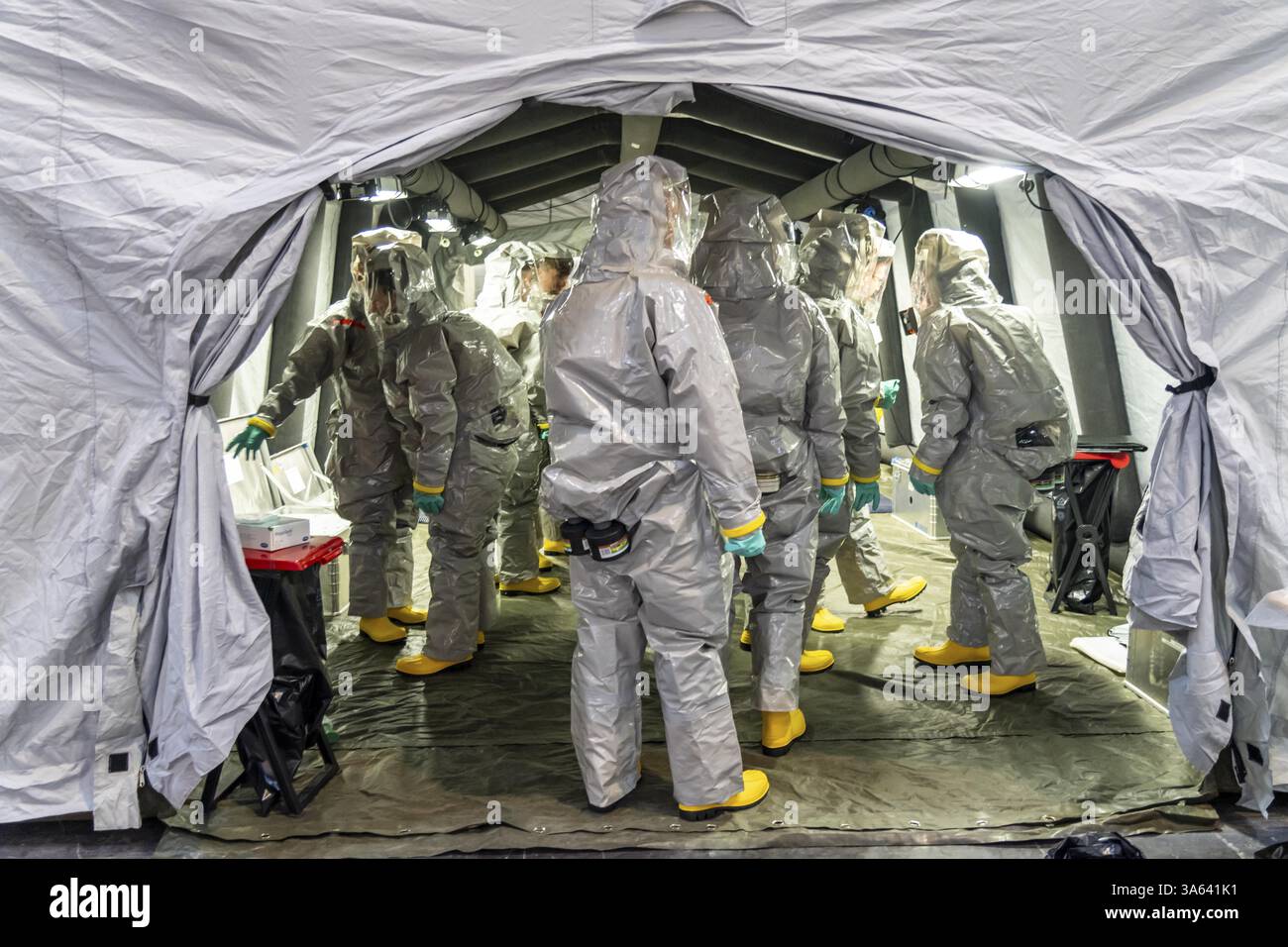 La decontaminazione delle persone ferite dopo un presunto incidente che coinvolge sostanze pericolose, i vigili del fuoco e le organizzazioni umanitarie esercitano la creazione di un Foto Stock