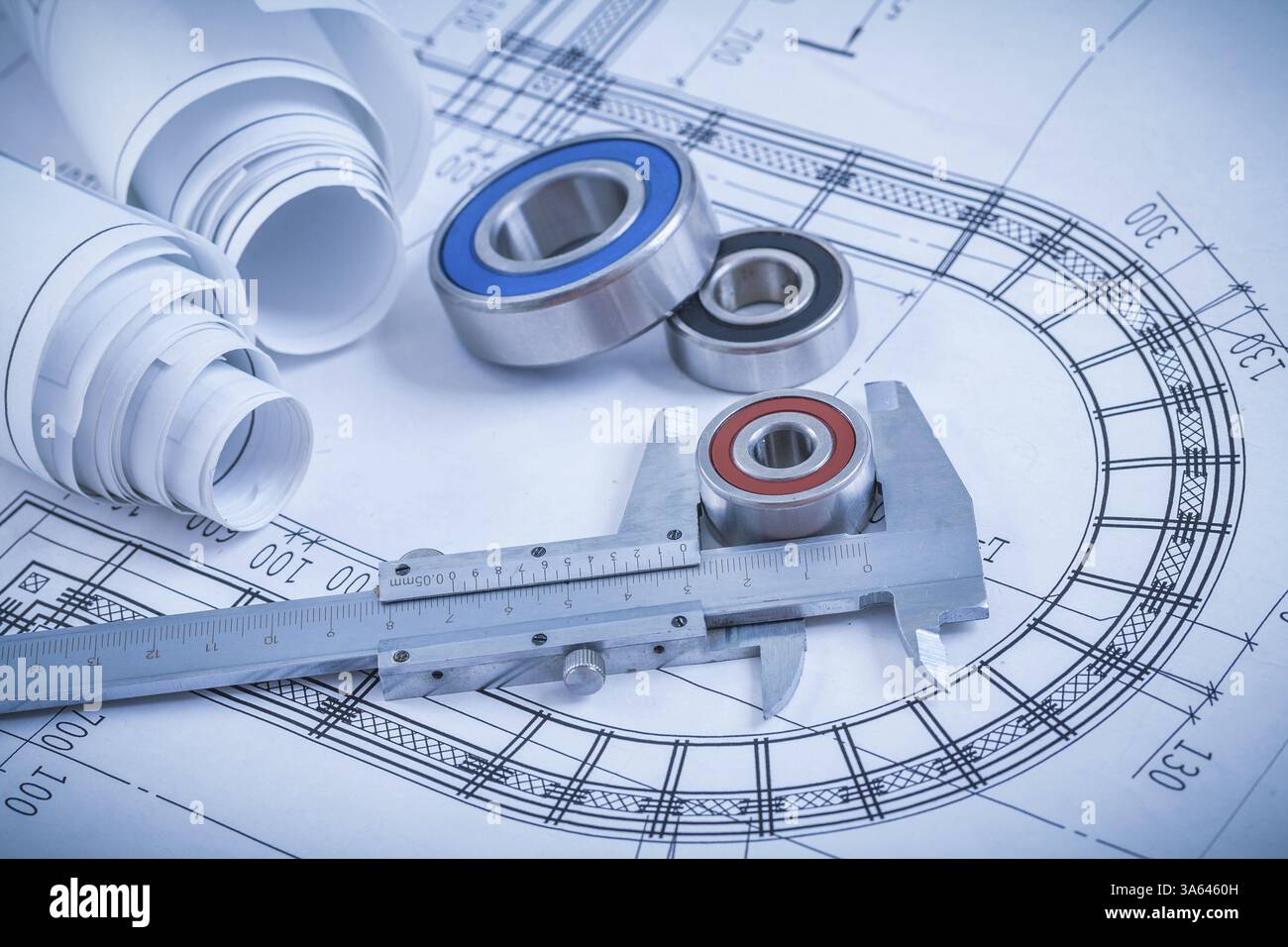 Piani di costruzione arrotolati cuscinetti a rulli e calibro a corsoio sul concetto industriale Blueprint Foto Stock