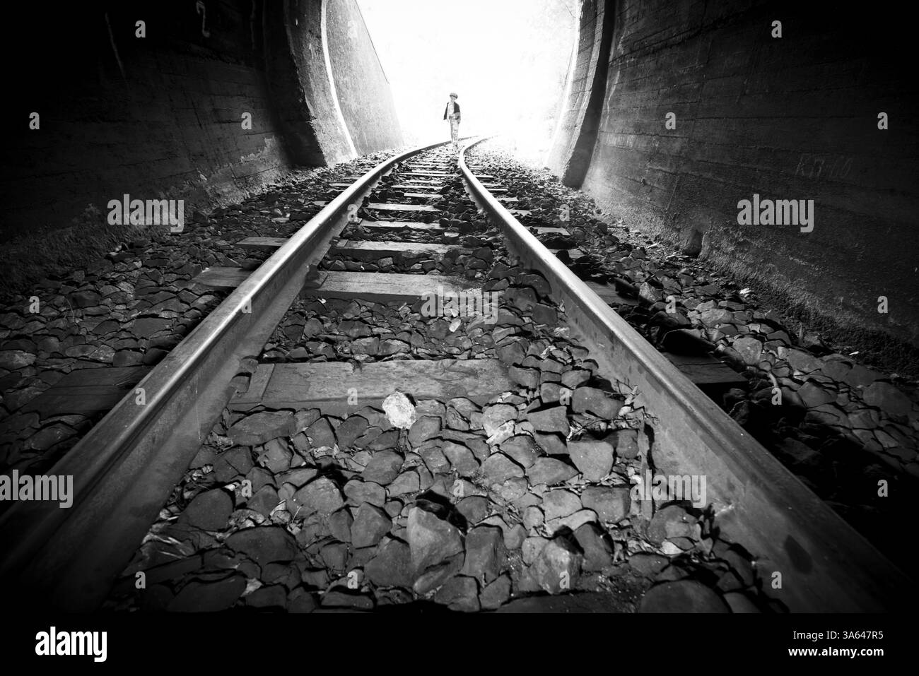 Bambino a piedi nella galleria ferroviaria. Abbigliamento vintage Foto Stock