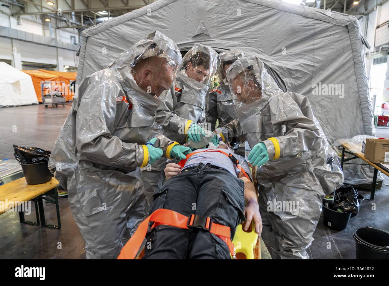 La decontaminazione delle persone ferite dopo un presunto incidente che coinvolge sostanze pericolose, i vigili del fuoco e le organizzazioni umanitarie esercitano la creazione di un Foto Stock