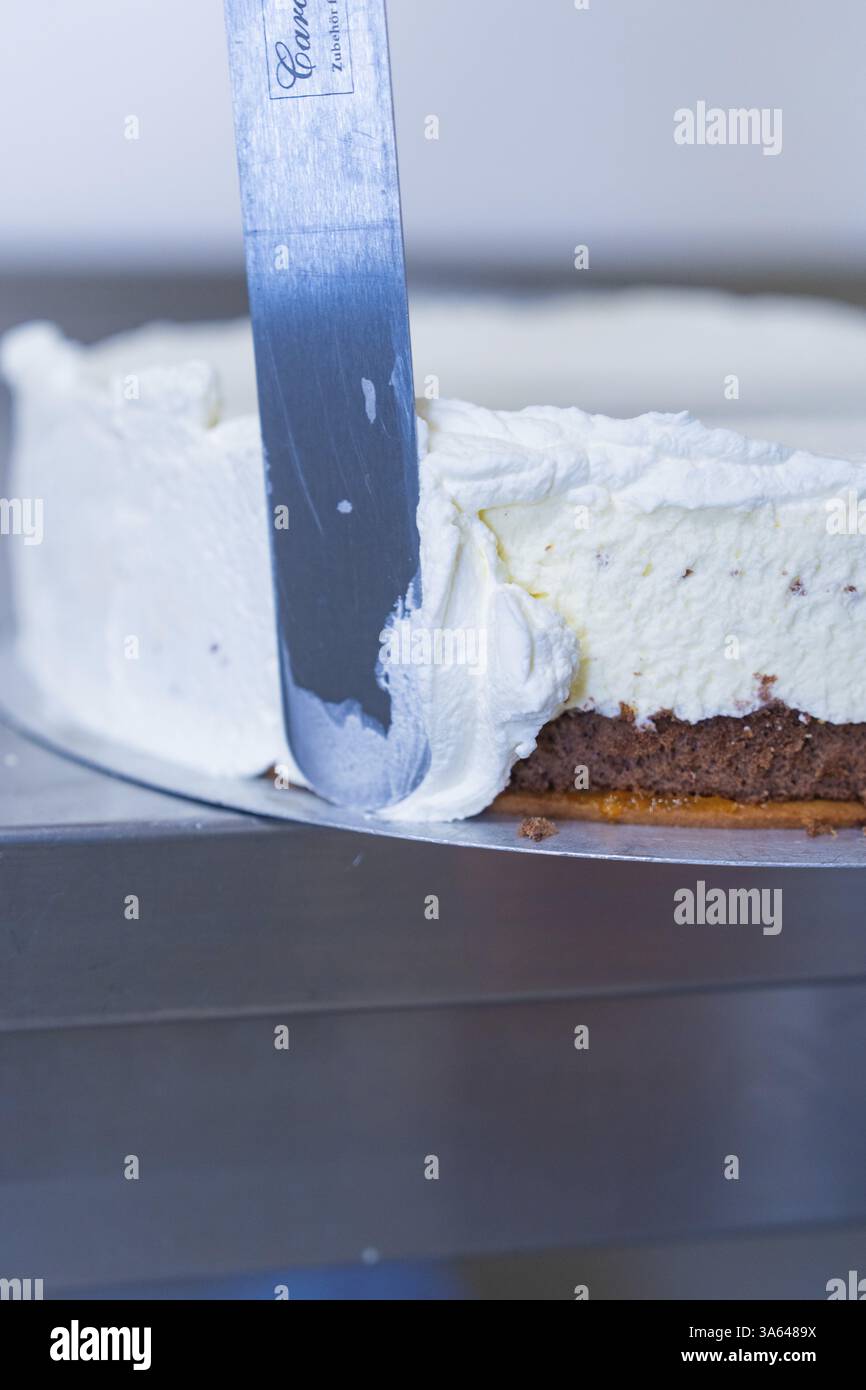 Una spatola viene utilizzata per spalmare la panna sul lato di una torta, cottura di torte, Haselstaller Hof Cafe Kuh, Wildberg, Foresta Nera, Germania, Europa Foto Stock