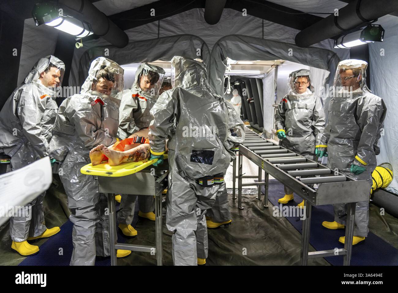 La decontaminazione delle persone ferite dopo un presunto incidente che coinvolge sostanze pericolose, i vigili del fuoco e le organizzazioni umanitarie esercitano la creazione di un Foto Stock