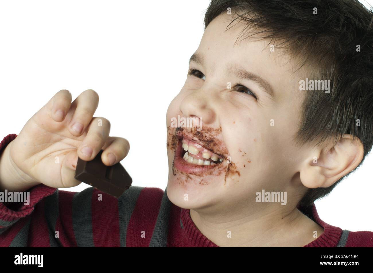 Sorridente kid mangiare cioccolato. Cosparsa colorate con labbra di cioccolato. White isolato Foto Stock