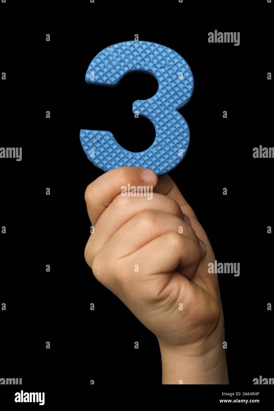 Bambini mano che tiene il numero tre. Isolato nero blu numero tre Foto Stock
