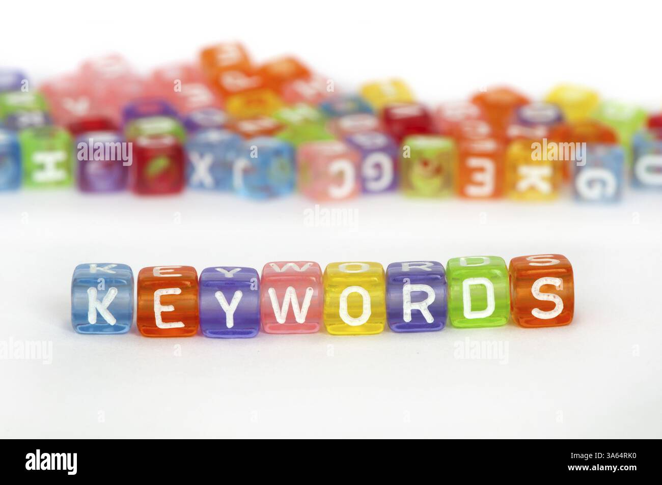 Testo parole chiave su cubi colorati su bianco. Casualmente disperse i cubi su sfondo Foto Stock