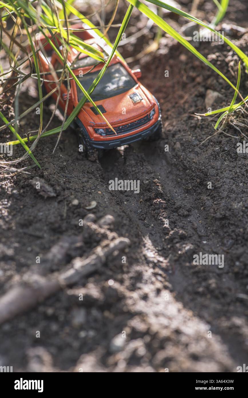 Piccolo rosso off road auto giocattolo in natura. Miniatura Foto Stock