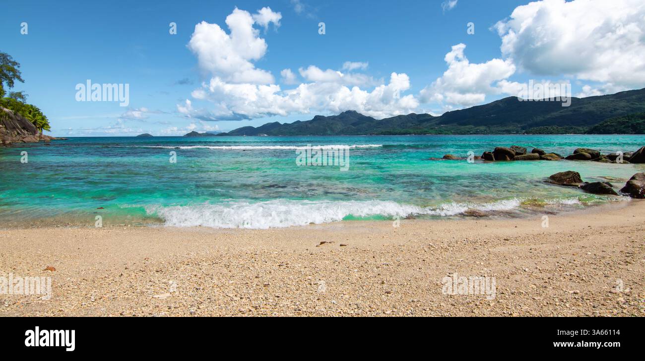 Vista panoramica della spiaggia tropicale con cielo blu. Isola di Mahé, Seychelles Foto Stock