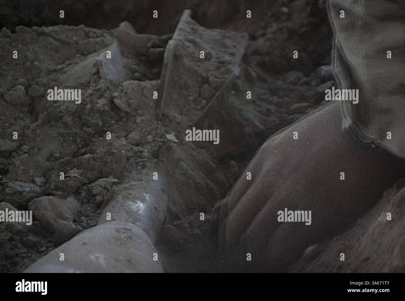 18 agosto 2004; AR Ramadi, Iraq; Un ingegnere dei Marines con il 2nd Battalion, il 4th Marine Regiment scava un colpo di mortaio da 160 mm da un deposito di armi nascosto in un fienile durante l'operazione Showdown ad AR Ramadi, 18 agosto. Foto Stock